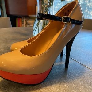 Beige pumps with 5” black stiletto heel and ankle strap